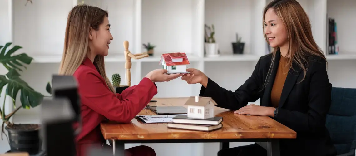 A property valuer and a real estate agent discussing property value